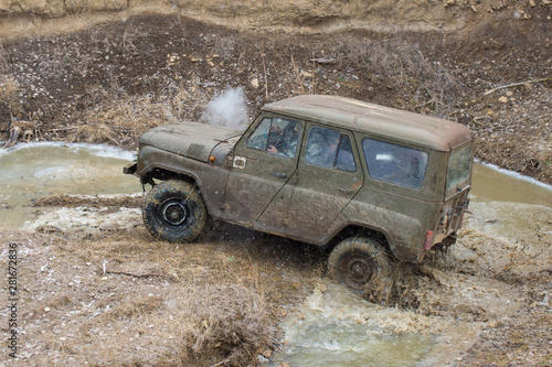 Rally on Russian SUVs in the mud in winter, Trapped all-terrain vehicle pulled out of the river 