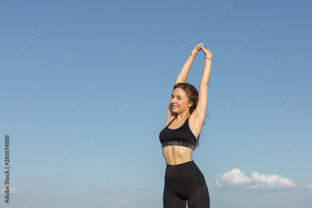 Slim athletic girl throws up her hands to the side of pleasure against the sky. Happiness, success, joy! Slim athletic girl throws up her hands to the side of pleasure against the sky. Happiness, success, joy!