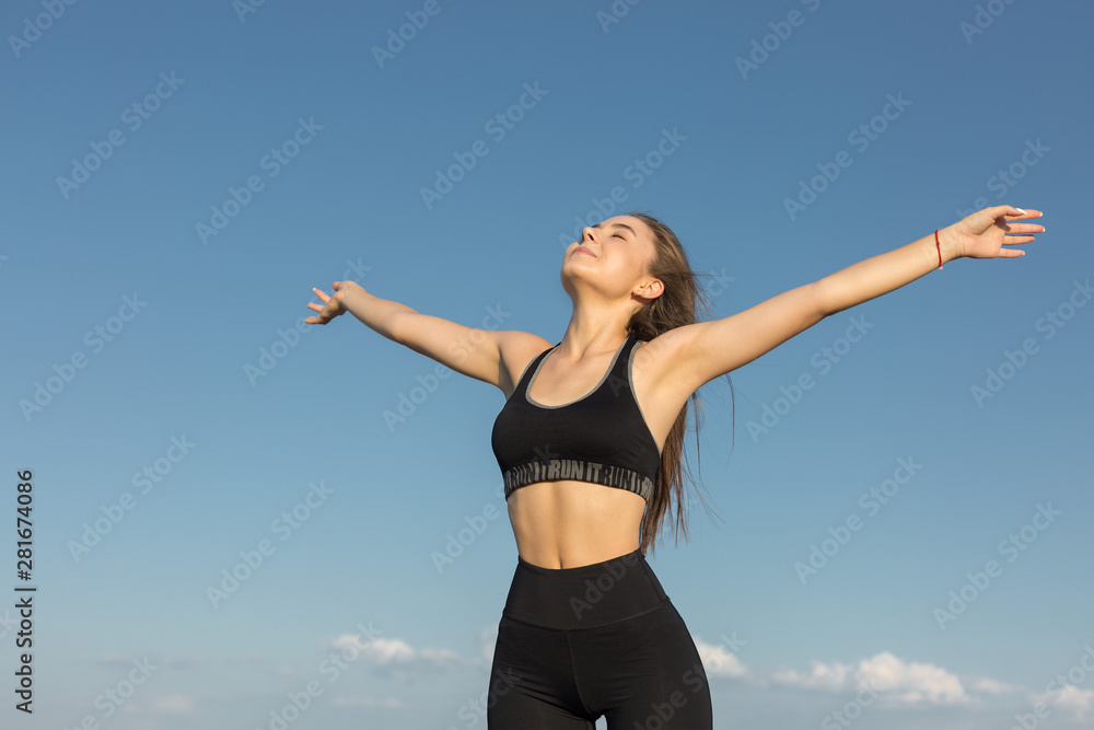 Slim athletic girl throws up her hands to the side of pleasure against the sky. Happiness, success, joy! Slim athletic girl throws up her hands to the side of pleasure against the sky. Happiness, success, joy!