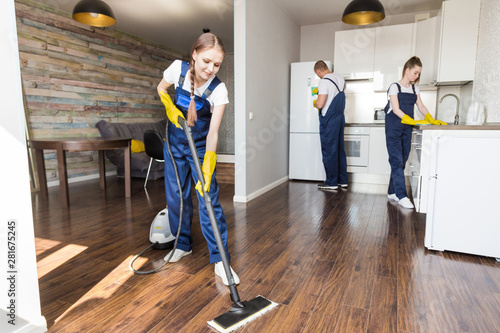 Cleaning service with professional equipment during work. professional kitchenette cleaning, sofa dry cleaning, window and floor washing. man and women in uniform, overalls and rubber gloves