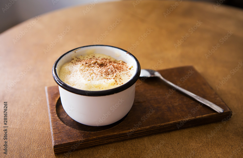 a cup of cappuccino stands on a wooden table and stands for a spoon a cup of cappuccino stands on a wooden table and stands for a spoon