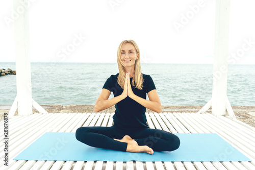 The white woman practices yoga, in the lotus position performs the namaste ritual. Healthy lifestyle and mental comfort. Positive thinking. photo