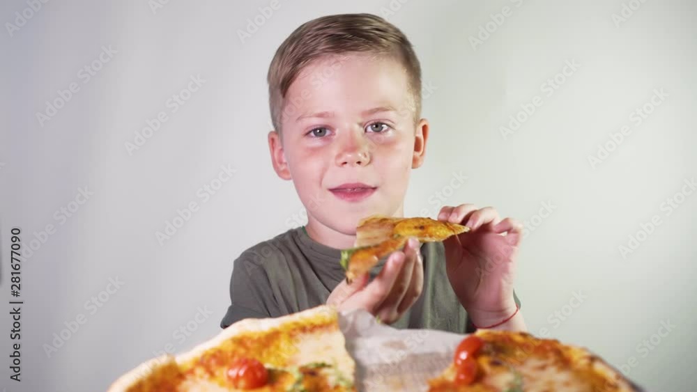 Cute Little Boy Eating Pizza With Pleasure on a White Background