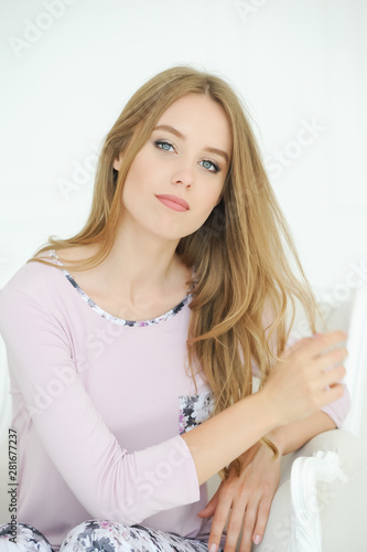 Beautiful sexy blonde woman wearing a pajama, smiling happily.
