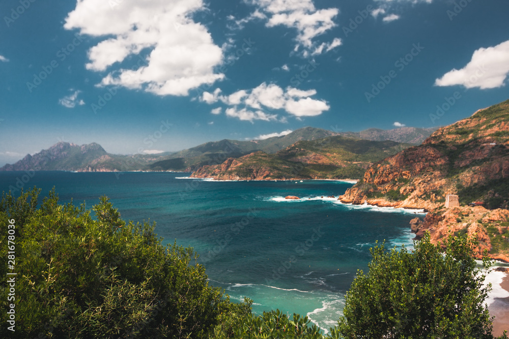 View to sea, red rocky coast and a Genoese tower, Corsica, France