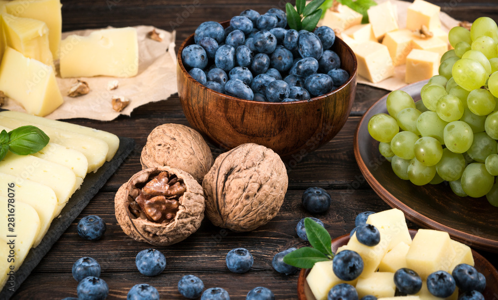 Tasting dish of cheese, blueberry and honey on a wooden background Tasting dish of cheese, blueberry and honey on a wooden background