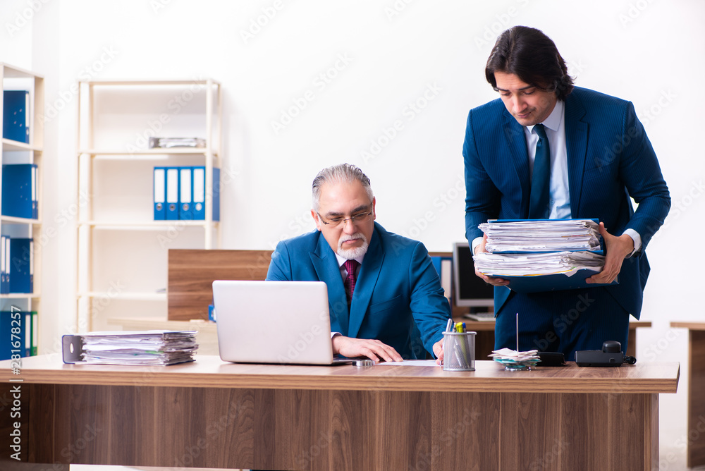 Young and old employees working together in the office Young and old employees working together in the office