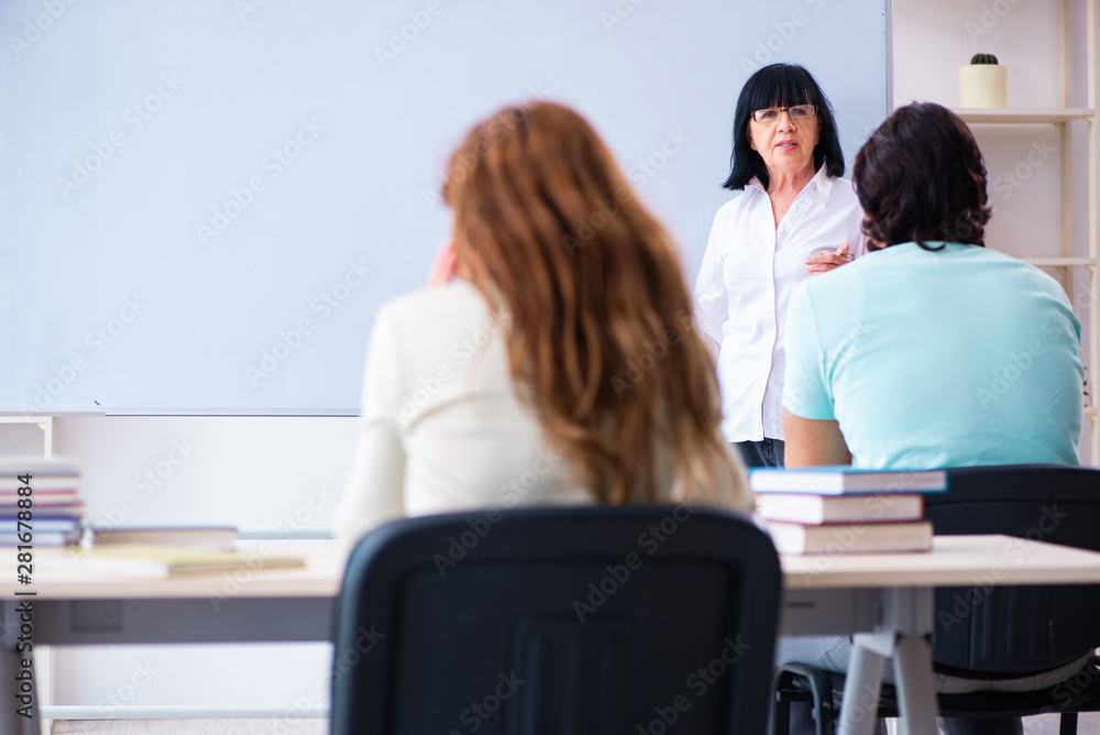 Old female english teacher and students in the classroom