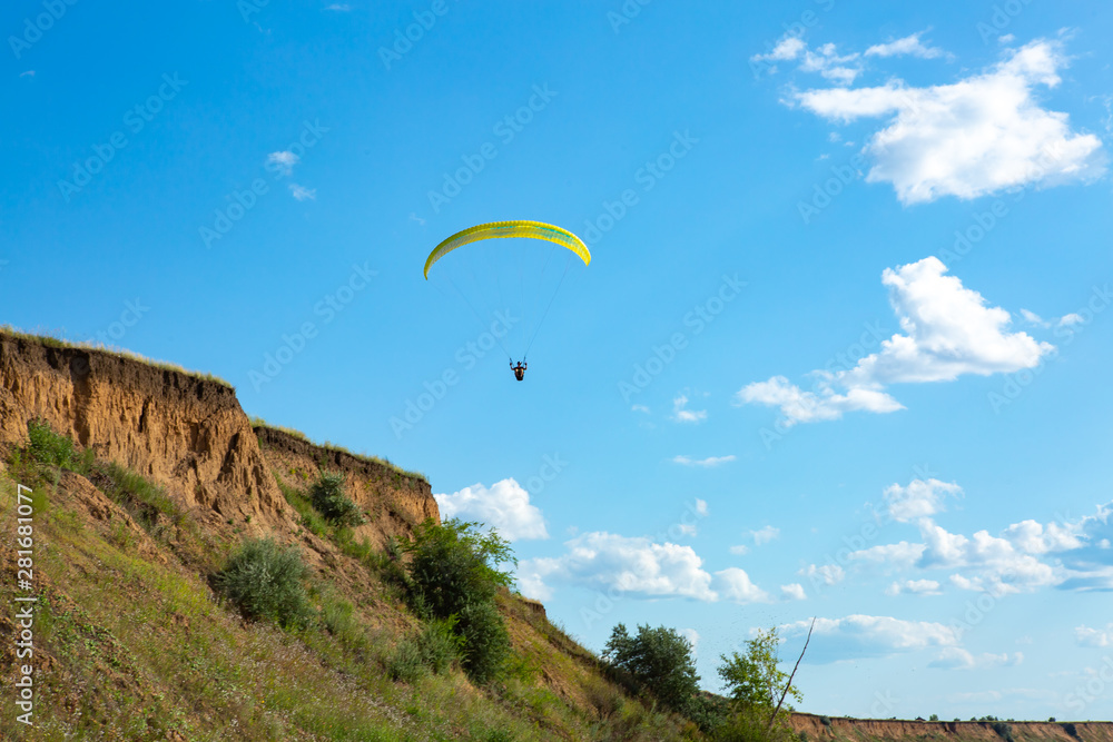 paraglider flying in the blue sky among the white clouds. Paragliding paraglider flying in the blue sky among the white clouds. Paragliding