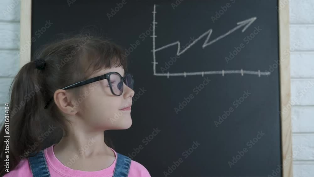 A chart on a blackboard. Little girl on the background of the drawn growth graph. A chart on a blackboard. Little girl on the background of the drawn growth graph.