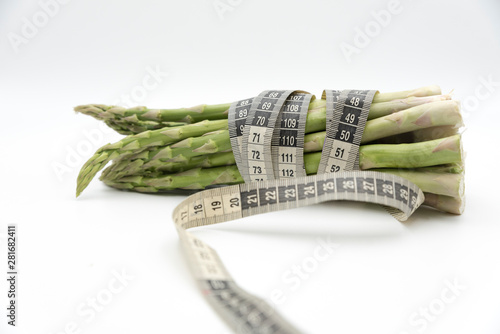 Asparagus surrounded by a medical tape on weighing scale for diets