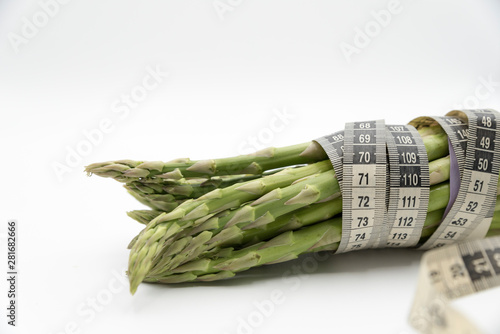 Asparagus surrounded by a medical tape on weighing scale for diets