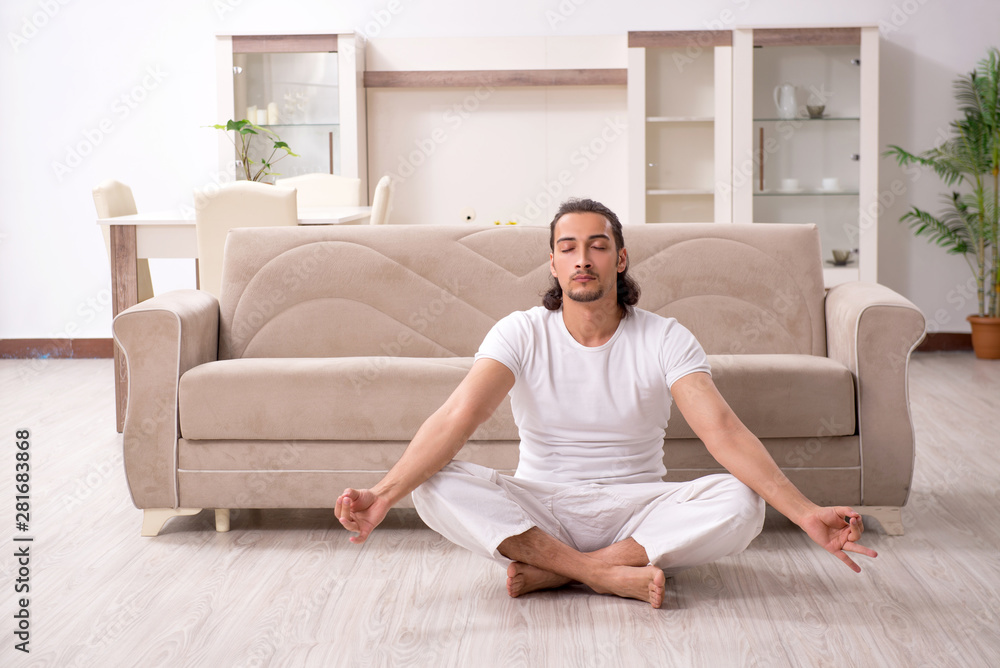 Young man doing physical exercises at home Young man doing physical exercises at home