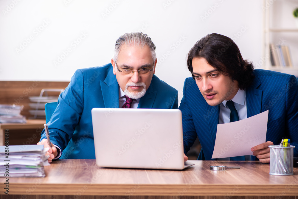 Young and old employees working together in the office Young and old employees working together in the office