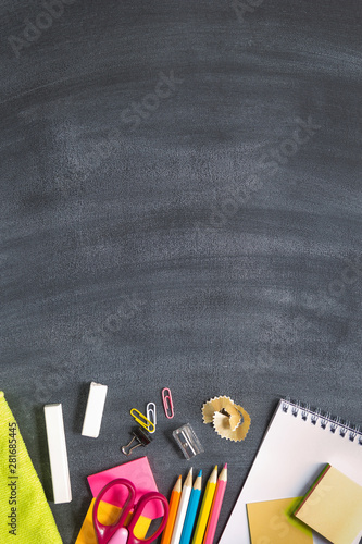 School supplies on a blackboard background. Concept back to school. With copy space. Top view. Vertical layout