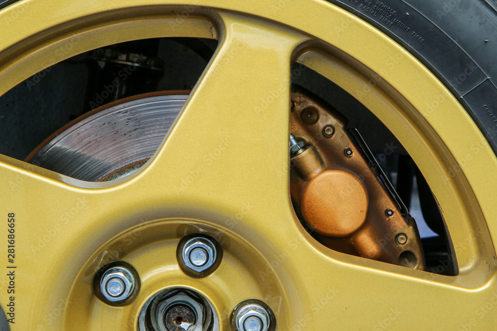 The detail of a Wheel of a rallye car with part of the rim, brake disc and calipers visible. 