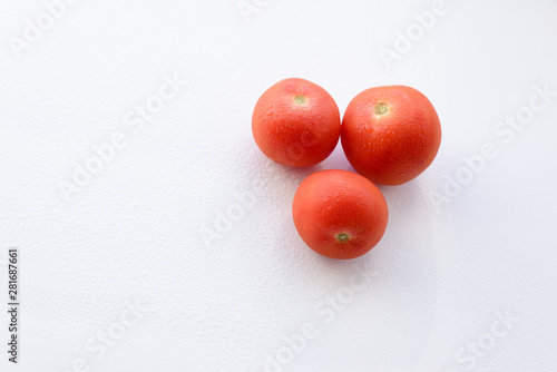 three tomatoes on the white surface