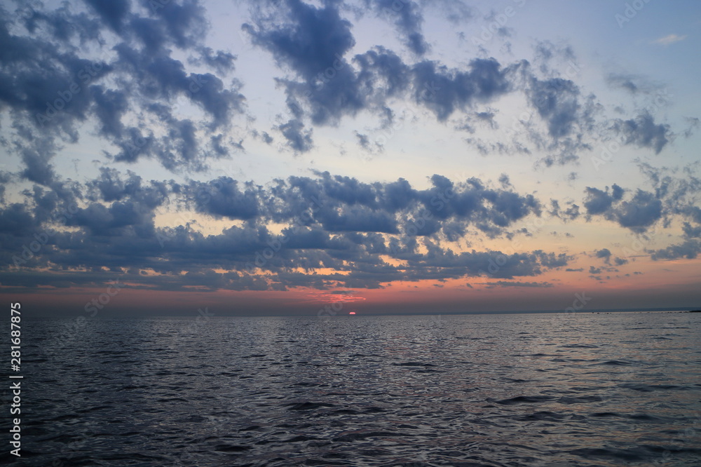 Fototapeta premium purple sunset dramatic seascape, sun drowned in the sea, panorama