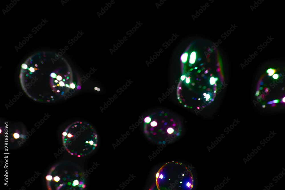 Dark blurred background with round colorful soap bubbles Dark blurred background with round colorful soap bubbles