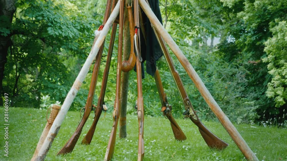 A pyramid of old rifles standing in the forest. Camp during the development of the American continent and the wars with the Indians A pyramid of old rifles standing in the forest. Camp during the development of the American continent and the wars with the Indians