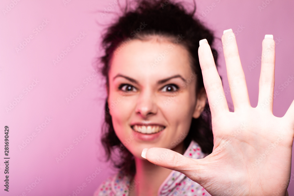 beautiful curly girl in pajamas, pink background