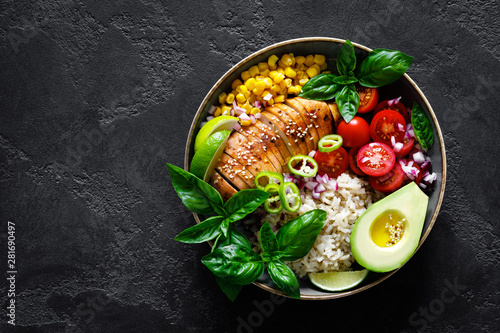 Grilled chicken breast lunch bowl with fresh tomato, avocado, corn, red onion, rice and basil photo