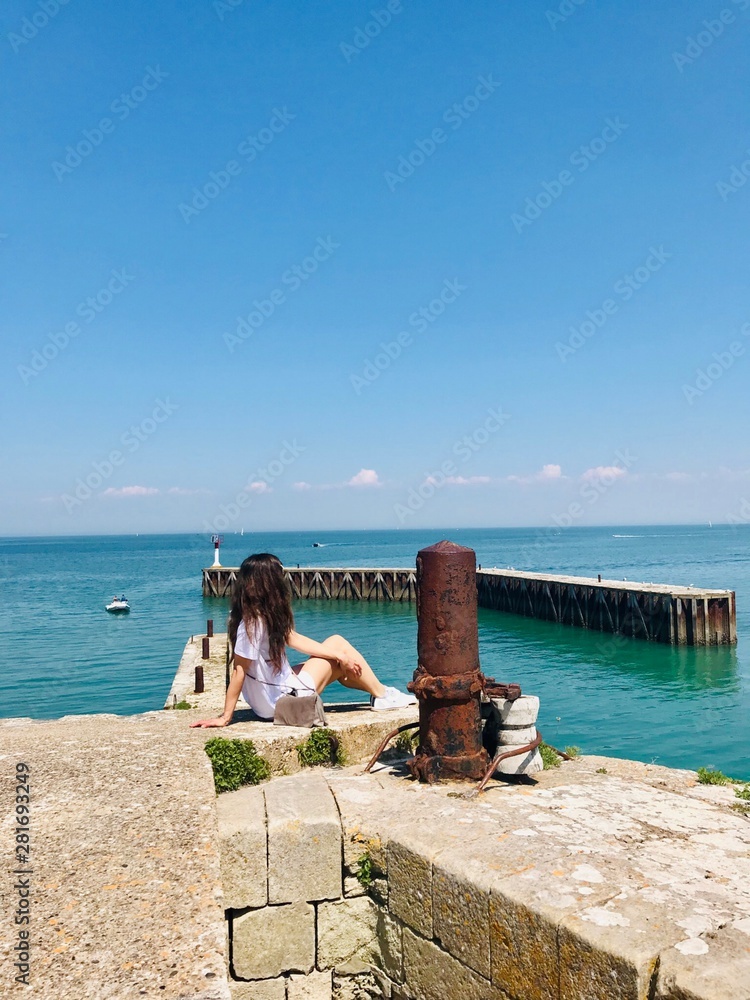 woman sitting on a bench and looking at the sea