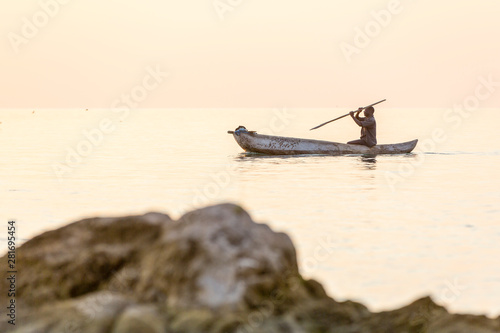 dugout canoe fishermen silhouette against orange sunrise on Lake Malawi, the sun glitter on the Lake, South-East-Africa photo