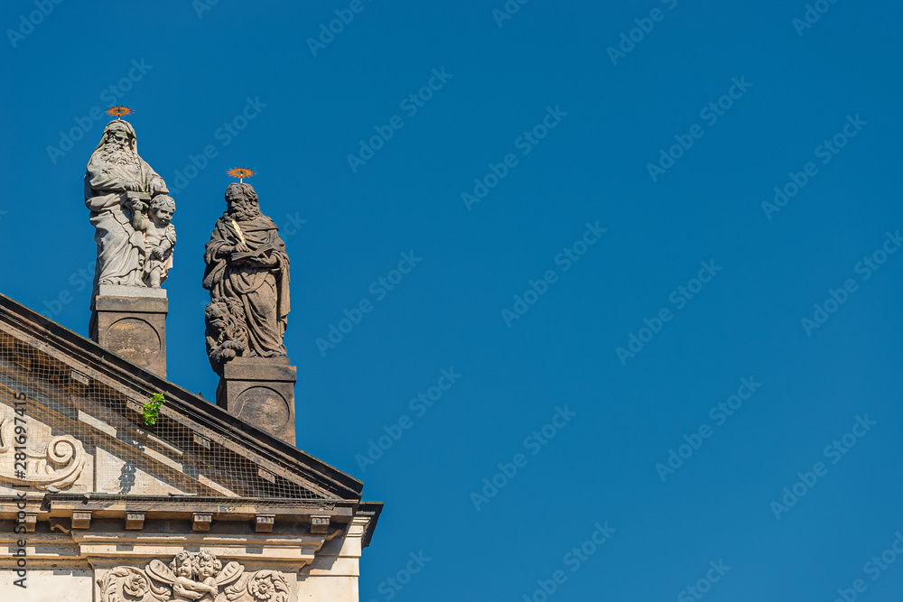 Decorative facade statues of priests and bishops at Saint Salvator church near Charles Bridge in Prague, Czech Republic, summer time, details