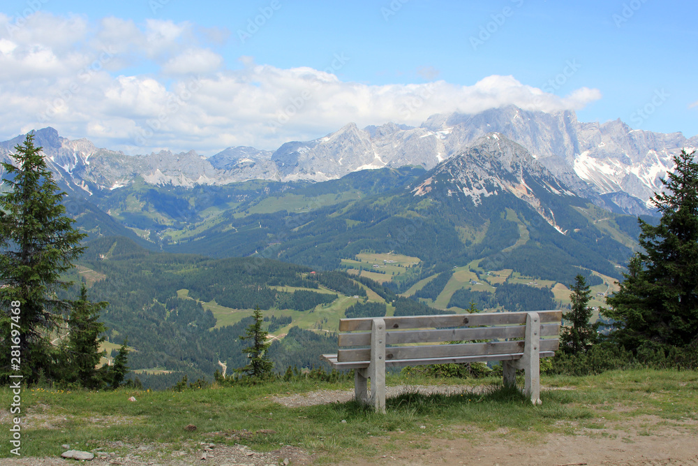 bench at the top of the mountain overlooking the forest and mountain peaks