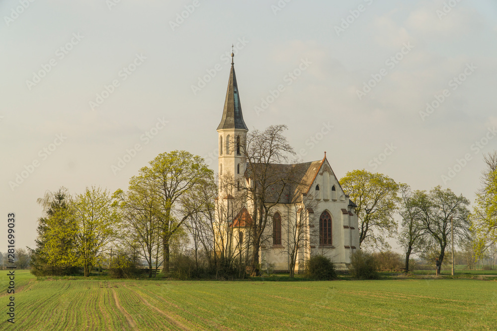 Neogothic Sidzina church in Lower Silesia standing alone amongst spring fields