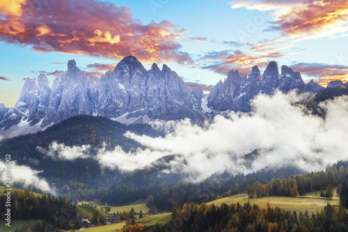 Beautiful landscape of Dolomite Alps in Italy. Amazing sunset landscape, dramatic sky over fantastic mountain ridge. Picturesque scenery of Alpine mountains. Valley of Santa Maddalena in Italy.