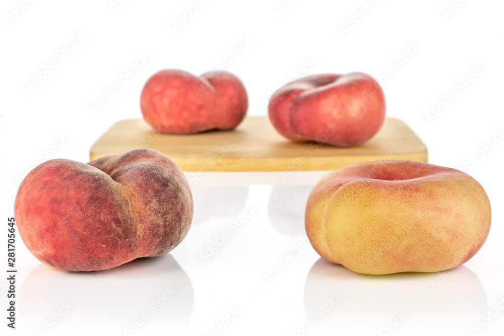 Group of four whole fresh red peach prunus persica platycarpa on bamboo cutting board isolated on white background Group of four whole fresh red peach prunus persica platycarpa on bamboo cutting board isolated on white background