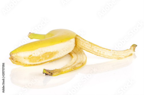 One whole ripe yellow banana halfway peeled isolated on white background