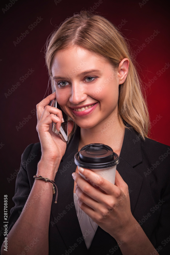Business young lady talking on her phone and drinking her coffee, looking happy