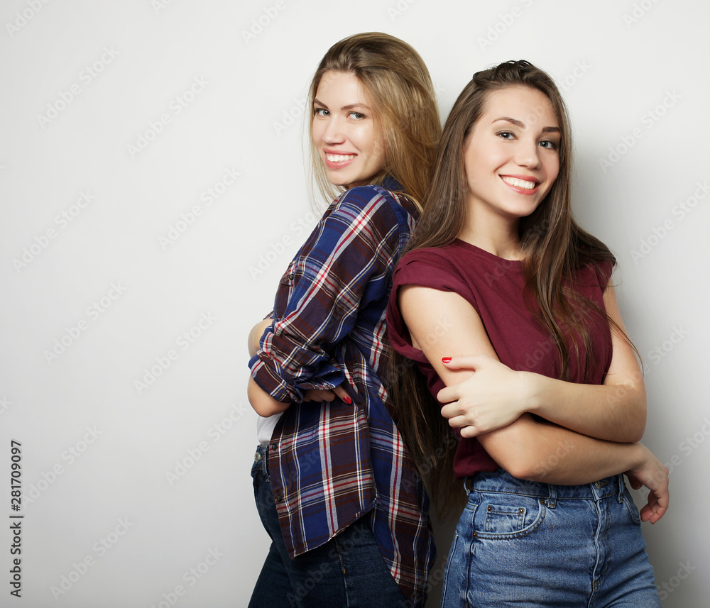 lifestyle and people concept: Two young girl friends standing together and having fun. Looking at camera. lifestyle and people concept: Two young girl friends standing together and having fun. Looking at camera.