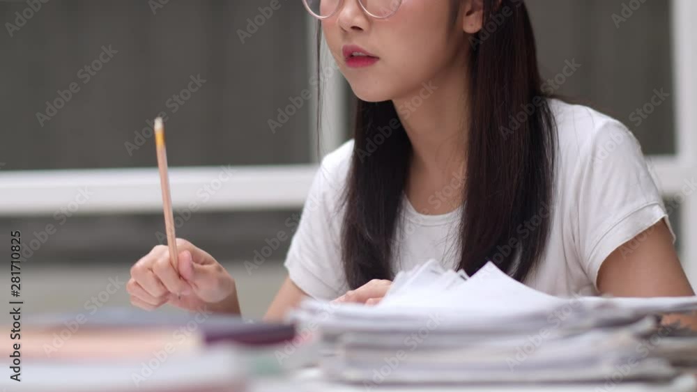 Asian student women reading books in library at university. Young undergraduate girl do homework, read textbook, study hard for knowledge and education on lecture desk at college campus. Slow motion. Asian student women reading books in library at university. Young undergraduate girl do homework, read textbook, study hard for knowledge and education on lecture desk at college campus. Slow motion.
