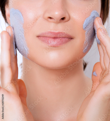 portrait of young woman with perfect skin using face mask