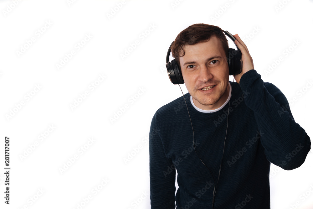beautiful young man in headphones is dancing isolated on white background. The concept of International Music Day. beautiful young man in headphones is dancing isolated on white background. The concept of International Music Day.