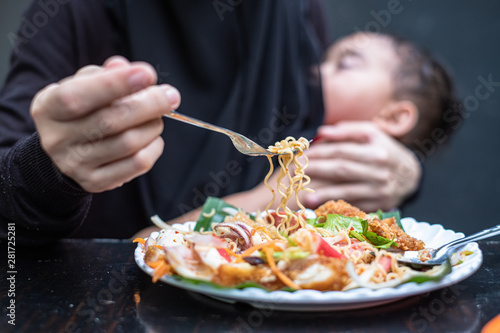 Mother eating spicy while baby sleep and breastfeeding in the restuarant. Baby in mother s hugging and breastfeeding while mother is eating.