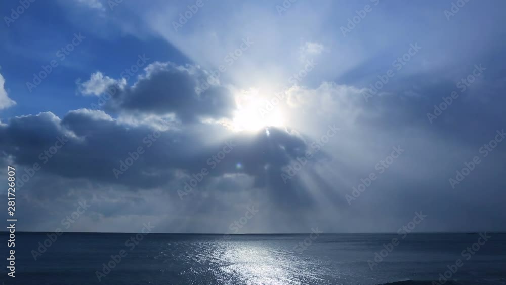 Timelapse of sunlight piercing clouds over blue ocean Timelapse of sunlight piercing clouds over blue ocean