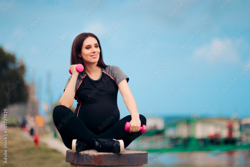 Active Pregnant Woman Using Dumbbells Outdoors