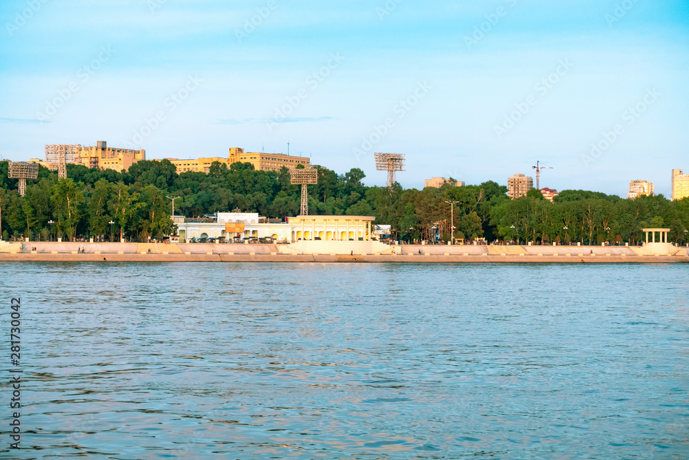 Naklejka premium View of the city of Khabarovsk from the Amur river. Urban landscape in the evening at sunset.