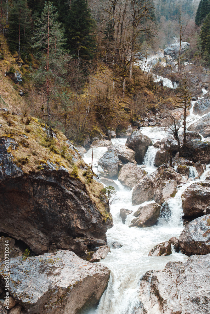 Small cliffy mountain spring waterfall in Abkhazia. Craggy ridge cliff with water bursts. Cold water rocky mountains of waterfall. Rock mountains falling stream. Small cliffy mountain spring waterfall in Abkhazia. Craggy ridge cliff with water bursts. Cold water rocky mountains of waterfall. Rock mountains falling stream.