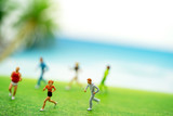 Miniature people: Tourists running on the beach. Summer Concept.