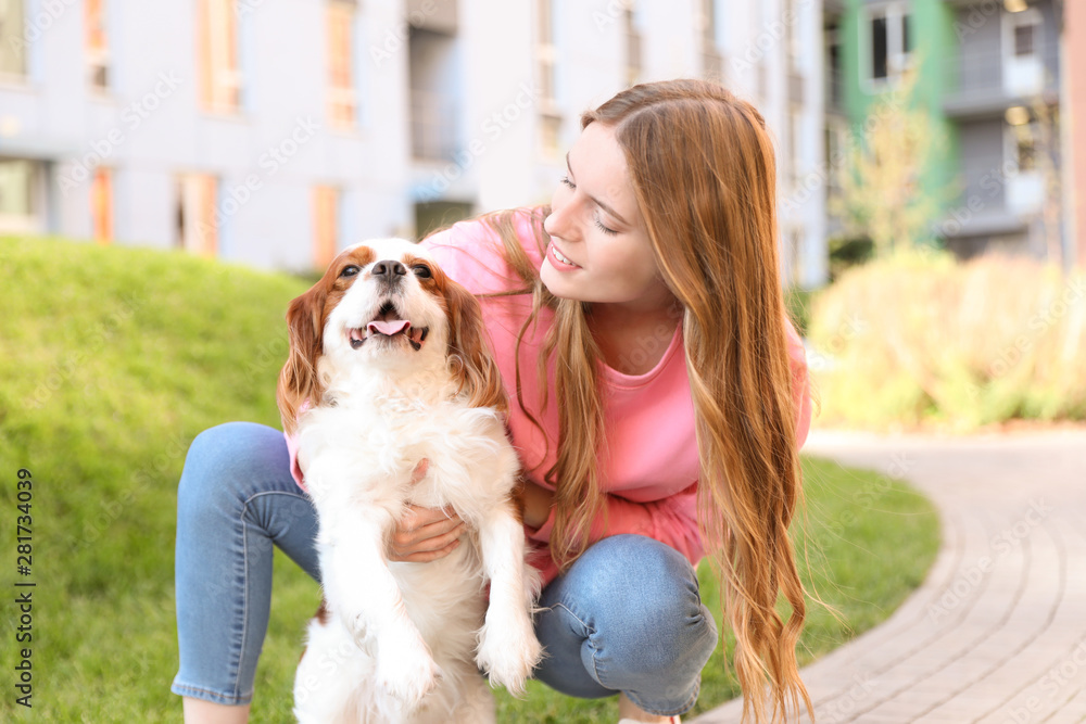 Young woman with adorable Cavalier King Charles Spaniel dog outdoors Young woman with adorable Cavalier King Charles Spaniel dog outdoors