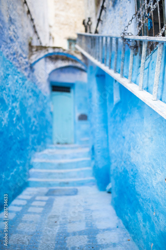 (Selective focus) Stunning view of a narrow alleyway with the striking, blue-washed buildings. Chefchaouen, or Chaouen, is a city in the Rif Mountains of northwest Morocco. © Travel Wild