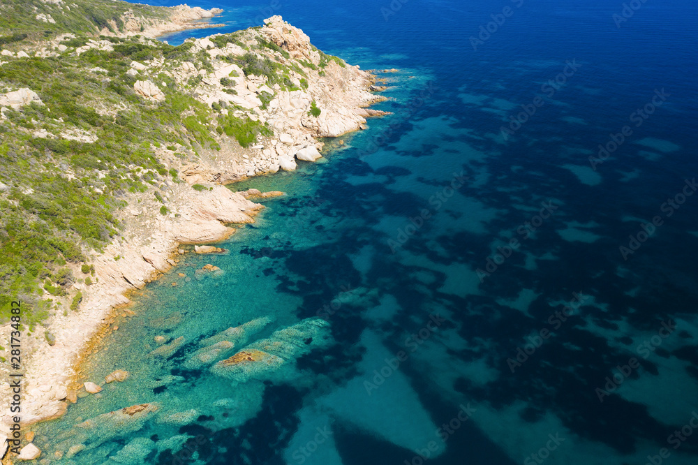 View from above, stunning aerial view of a green rocky coast bathed by a beautiful turquoise sea. Costa Smeralda (Emerald Coast) Sardinia, Italy.