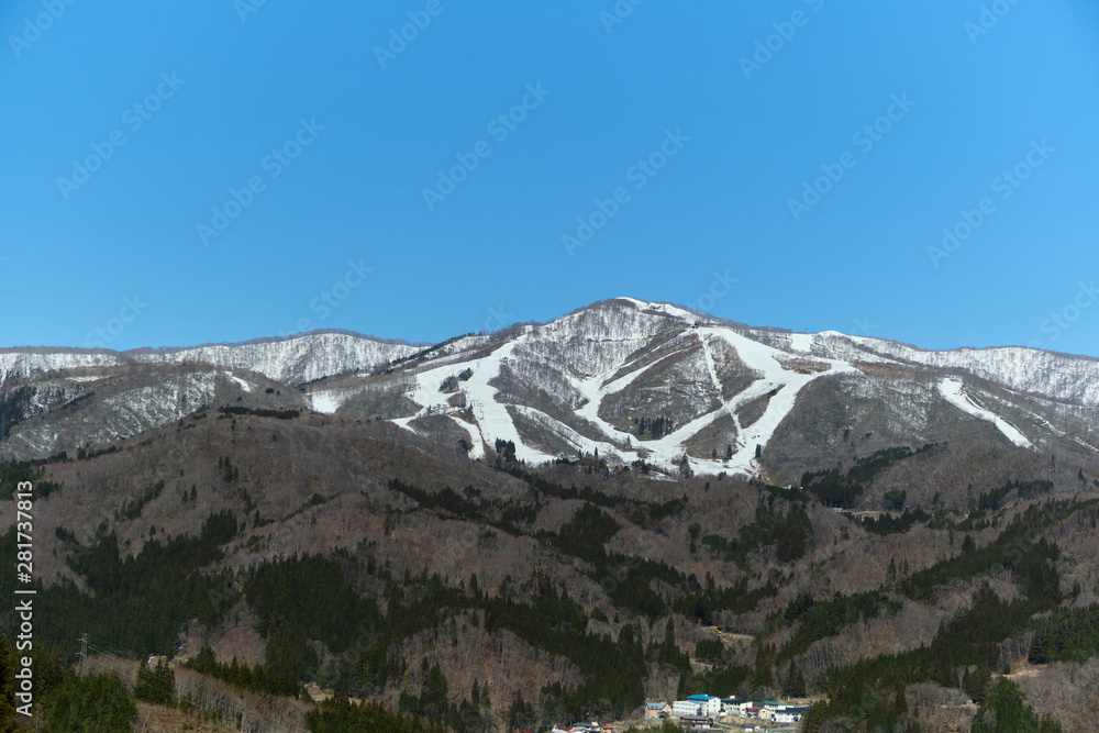Beautiful view of Snowy mountains with small town in front and clear blue sky on the way to Shirakawago Japan Beautiful view of Snowy mountains with small town in front and clear blue sky on the way to Shirakawago Japan