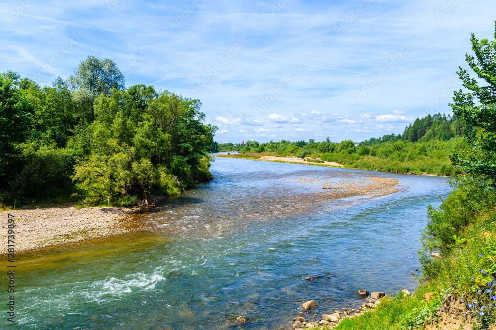 Dunajec river with green hills on shore on sunny summer day near Nowy Targ, Tatra Mountains, Poland Dunajec river with green hills on shore on sunny summer day near Nowy Targ, Tatra Mountains, Poland